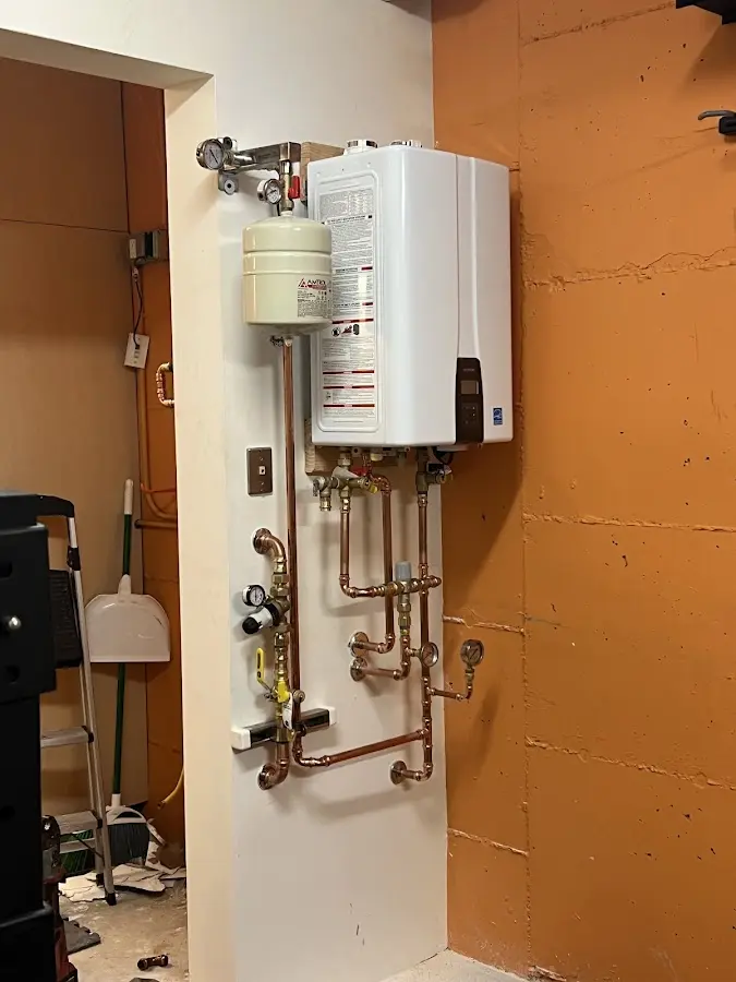 Plumbing technician inspecting water heater connections in Scottsville